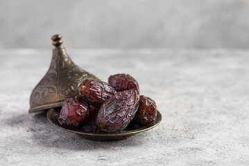 HURMA, Dates. Dried dates fruit with wooden plate on white background. Popular fruit of Ramadan. - obrazy, fototapety, plakaty