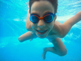 Young boy under the water of a swimming pool