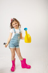 A little cute baby girl with dark hair and curly-haired plants in pots on a white background with a place to sign