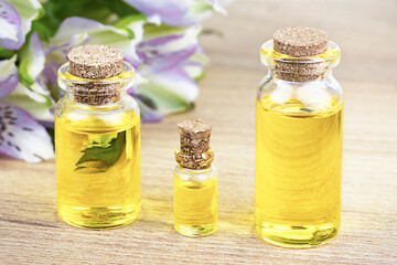 Bouteilles d& 39 huile essentielle avec des fleurs sur table. Concept médical alternatif.