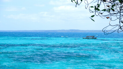 Beautiful view of ocean and blue sky background. Old traditional wooden african boat. Indian ocean. Tanzania, Zanzibar.