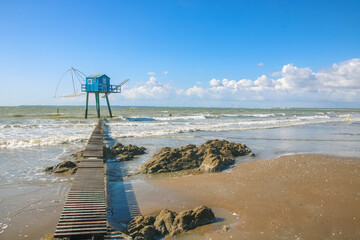 cabane de pêcheur bleue avec un filet à carrelet pour pêcher à marée haute sur la plage de...
