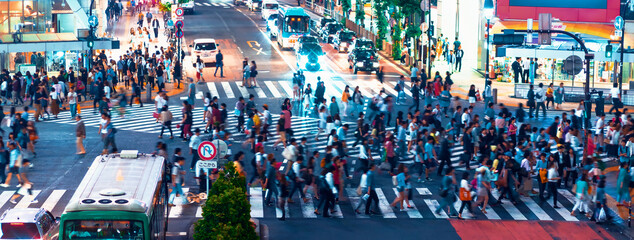 People and traffic cross the famous scramble intersection in Shibuya, Tokyo, Japan