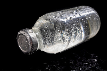 Glass bottles with fresh drinking water. Water drops on glass containers for water storage.