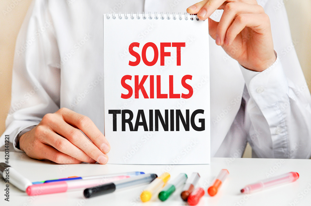Poster a sheet of paper with text soft skills training, multicolored markers on a white table. business and