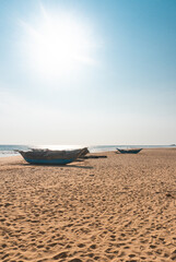 Krajobraz wybrzeża z łodziami rybackimi, plaża i ocean na tle niebieskiego nieba. © insomniafoto