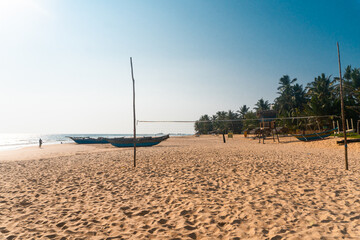 Krajobraz wybrzeża z łodziami rybackimi, plaża i ocean na tle niebieskiego nieba. © insomniafoto