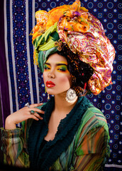 beauty bright woman with creative make up, many shawls on head like cubian, ethno look closeup