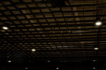Lights and ventilation system in long line on ceiling of the dark office industrial building, exhibition Hall Ceiling construction