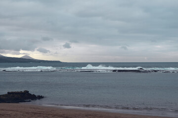 Big powerful waves at the beach hit breakwater. Winter season, windy and stormy weather. 