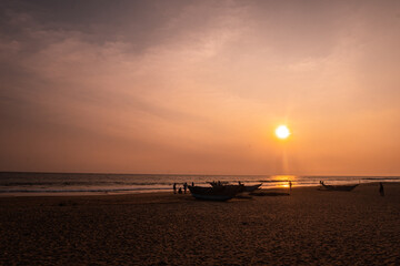 Piękny zachód słońca na plaży, tropikalny krajobraz z rybackimi łódkami.