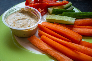 Healthy meal of sliced, raw vegetables with a humus dip