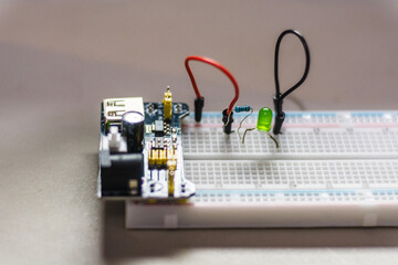 breadboard with a microcontroller board, electric resistors and led spotlight. Mechatronics project