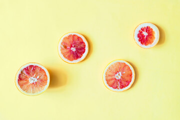 Sicilian Blood sliced oranges on yellow background close up. ripe juicy citrus fruits with copy...