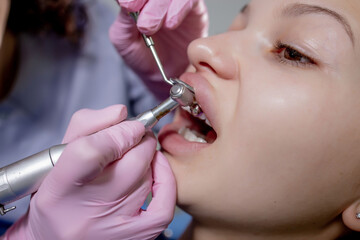 Health check. Dentist in stomatology center is making an examination of woman teeth by using dental tools