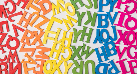 Top view photo of rainbow multicolor letters of english alphabet on white background