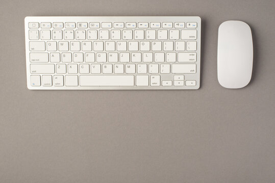 Above photo of keyboard and computer mouse isolated on the grey background with blank space