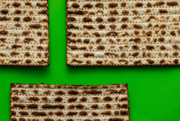 A close-up of three matzahs - bread for the Jewish Passover, on a green background