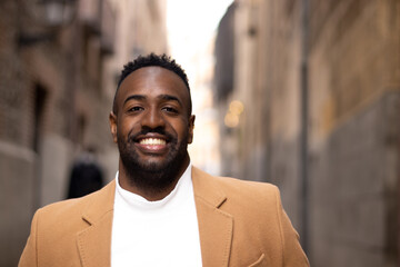 Obraz premium Black man portrait smiling on a street.