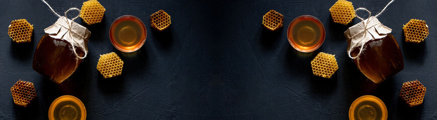 Jar of honey with honeycomb on black table, top view. space for text