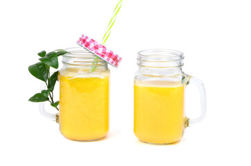 Orange juice and green leaves isolated on a white background.Two glasses of orange juice and drinking straw. Healthy food.