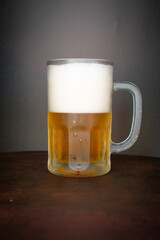 beer chopp on a brown leather-like surface and a black background