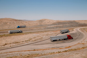 UTAH, USA - 12.06.2020 -Trucks  parked and driving along the highway in the Utah desert. Industrial transport and cargo transportation concept