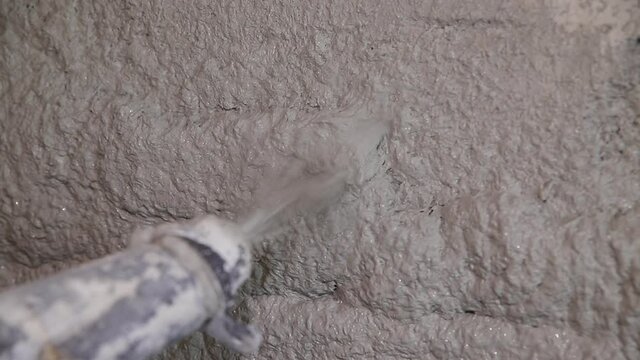 Plastering mortar machine. Automatic plaster. Repairing or renovating house or apartment. Builder at construction