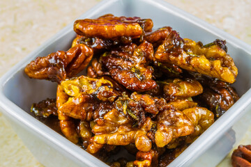 Roasted walnuts and pecan nuts in white pot, macro