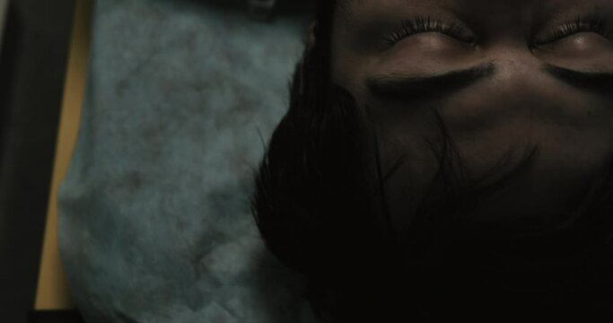 Top view of unconscious guy in 30s  on medical transportation cart on way to hospital.