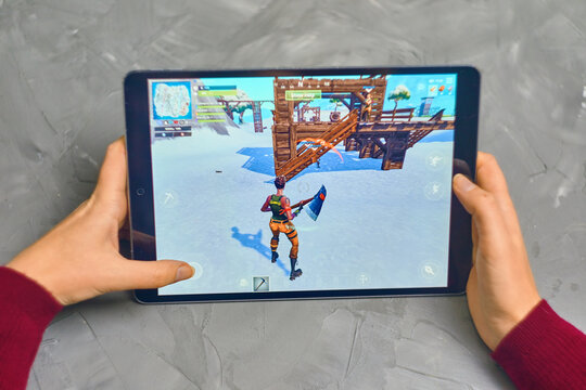 Bishkek, Kyrgyzstan - January 21, 2019: Woman playing fortnite game of epic games company on Apple ios tablet iPad Pro. Gameplay Action