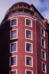 Looking up at modern red brick apartment building