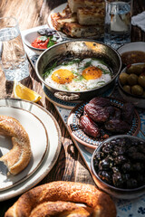 Delicious rich Traditional Turkish breakfast include tomatoes, cucumbers, cheese, butter, eggs, honey, bread, bagels, olives and tea cups. Ramadan Suhoor aka Sahur (morning meal before fasting). 