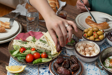 Delicious rich Traditional Turkish breakfast include tomatoes, cucumbers, cheese, butter, eggs, honey, bread, bagels, olives and tea cups. Ramadan Suhoor aka Sahur (morning meal before fasting). 