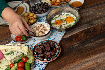 Delicious rich Traditional Turkish breakfast include tomatoes, cucumbers, cheese, butter, eggs, honey, bread, bagels, olives and tea cups. Ramadan Suhoor aka Sahur (morning meal before fasting). 
