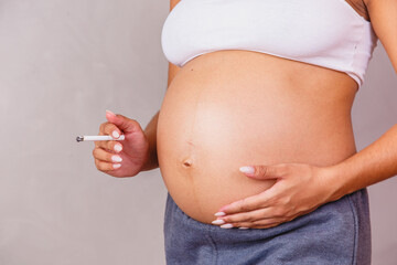 Pregnant African woman holding a cigarette criticizing smoking and saying no to smoking, and saying...