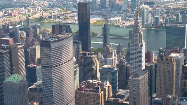 AERIAL CLOSE UP: Flying past high glassy skyscrapers and contemporary condominium apartment buildings in downtown Manhattan. Flying above New York City skyscrapers with Long island in the background