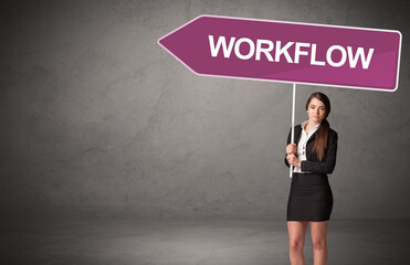 Young business person in casual holding road sign