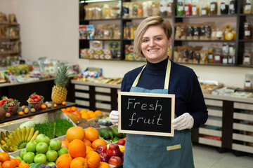 Portrait of a young saleswoman with a sign in her hands 