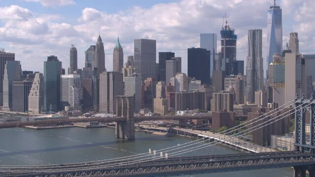 AERIAL: Beautiful view of iconic downtown New York skyscrapers, office buildings and Brooklyn and Manhattan Bridges across East River. Amazing New York City skyline cityscape on a gorgeous sunny day