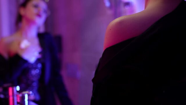 bdsm prostitute is wiping body by towel in bathroom of hotel room, looking at mirror