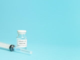 Selective focus close image of COVID 19 VACCINE with syringe isolated on white background.  