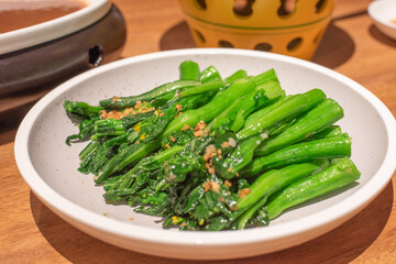 A dish of green vegetables with minced garlic