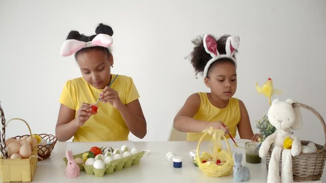 sisters coloring and designing eggs for ester