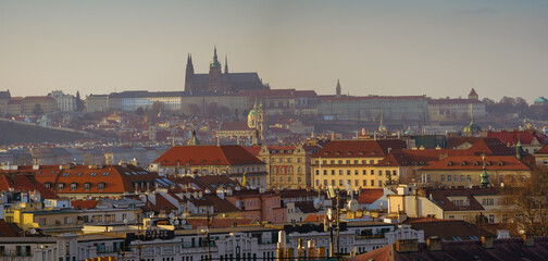 View of Prague Castle and St. Vitus Cathedral and the roofs of buildings in Prague at sunset