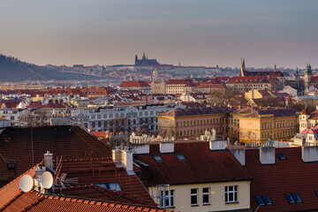 Fototapeta na wymiar View of Prague Castle and St. Vitus Cathedral and the roofs of buildings in Prague at sunset