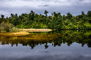 A beautiful peaceful lake in the middle of the native forest. South Island, New Zealand.