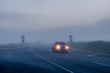 Car on the road on a misty morning. South Island, New Zealand.