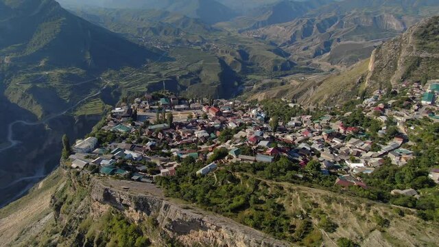 Dagestan epic rural landscape from great height. Authentic alpine village settlement Gunib on plateau high on top of mountain. Breathtaking rural summer mountainous scenery. Traditional houses town