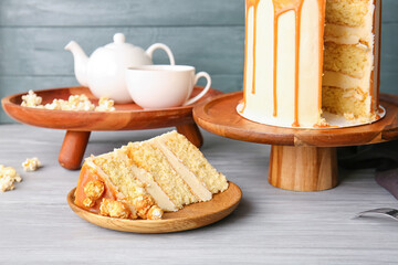 Tasty cake with popcorn and caramel on wooden background